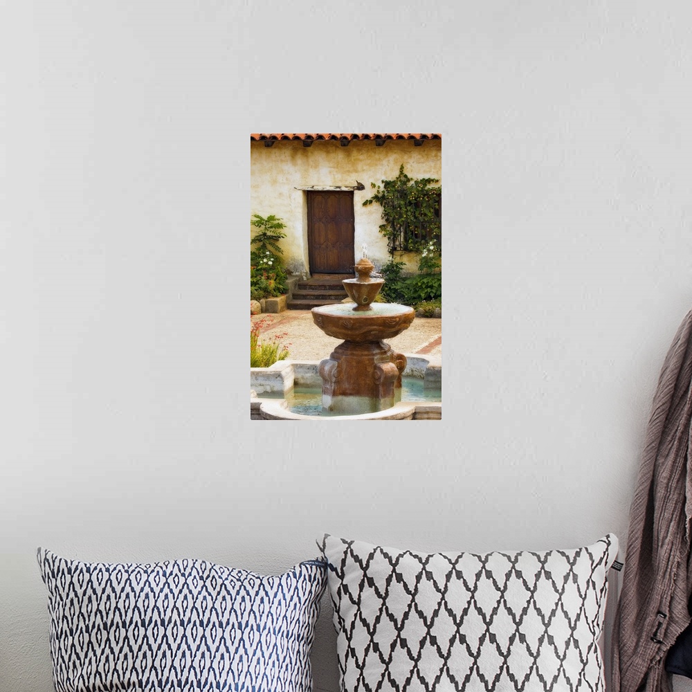A bohemian room featuring Photograph taken of a fountain sitting in front of a home with steps leading up to a wooden door....