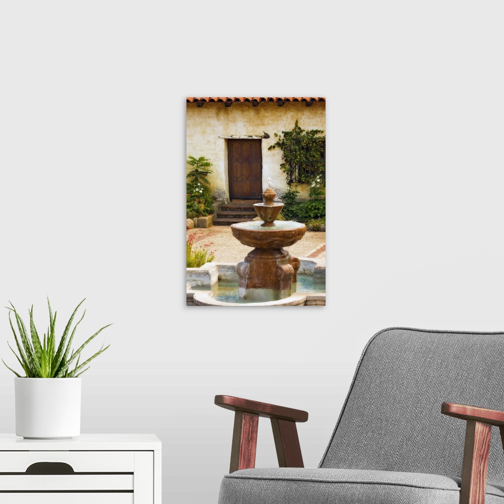 A modern room featuring Photograph taken of a fountain sitting in front of a home with steps leading up to a wooden door....