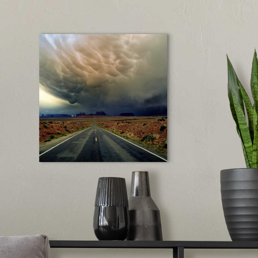 A modern room featuring Heavy storm clouds over a road through the desert in Monument Valley.