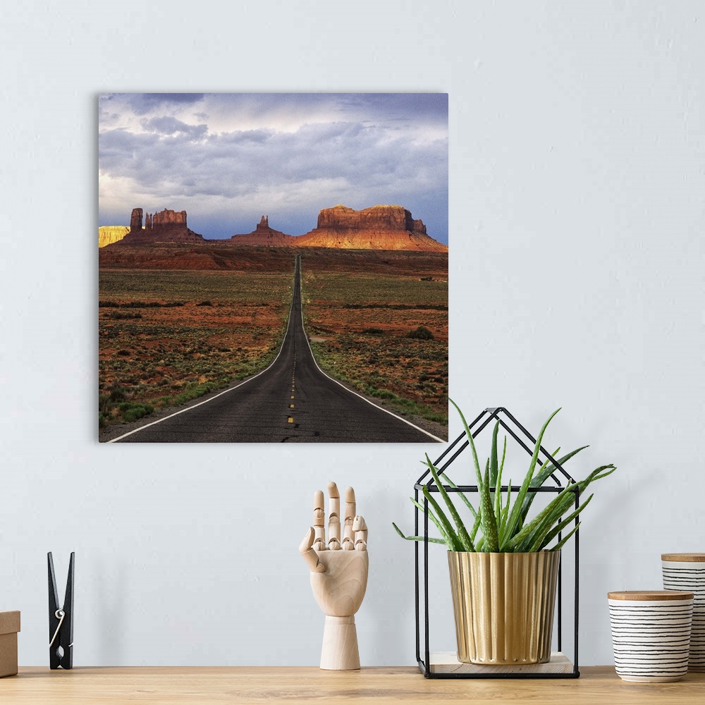 A bohemian room featuring A road leading towards the tall rock formations in Monument Valley, Arizona.