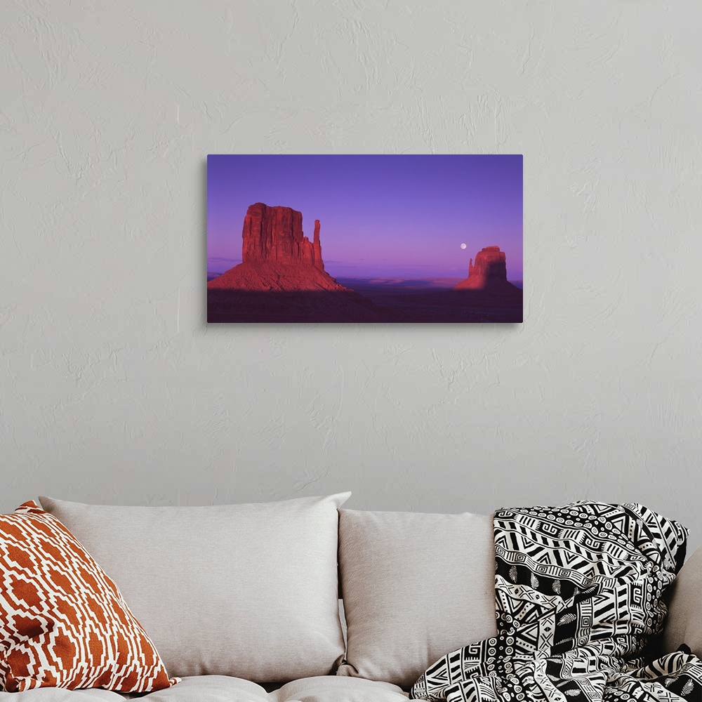 A bohemian room featuring The "Mittens" rock formations in Monument Valley, Arizona, at dusk.