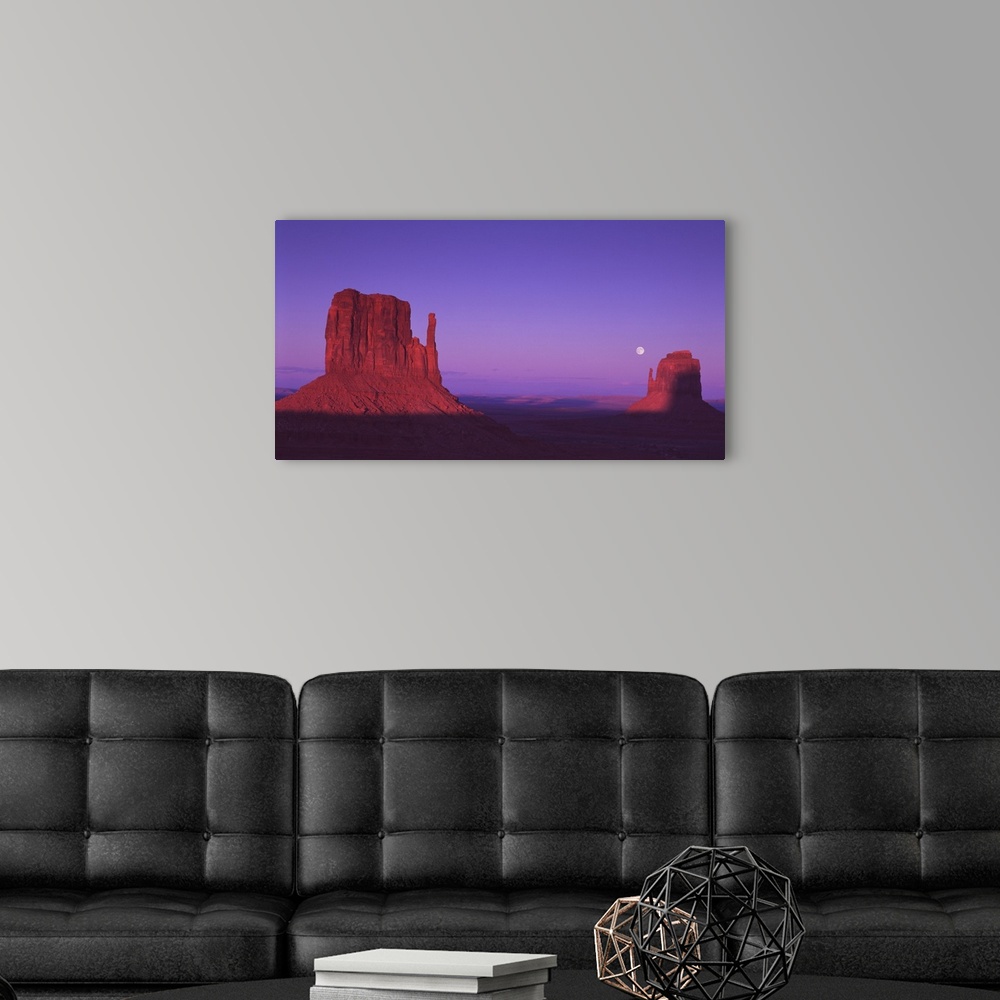 A modern room featuring The "Mittens" rock formations in Monument Valley, Arizona, at dusk.