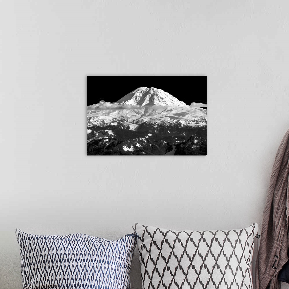 A bohemian room featuring Black and white landscape photograph of a snow covered mountain peak with clouds below.