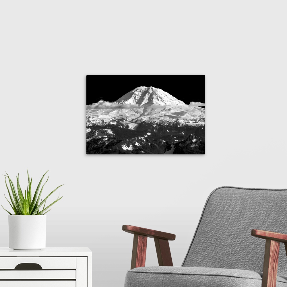A modern room featuring Black and white landscape photograph of a snow covered mountain peak with clouds below.