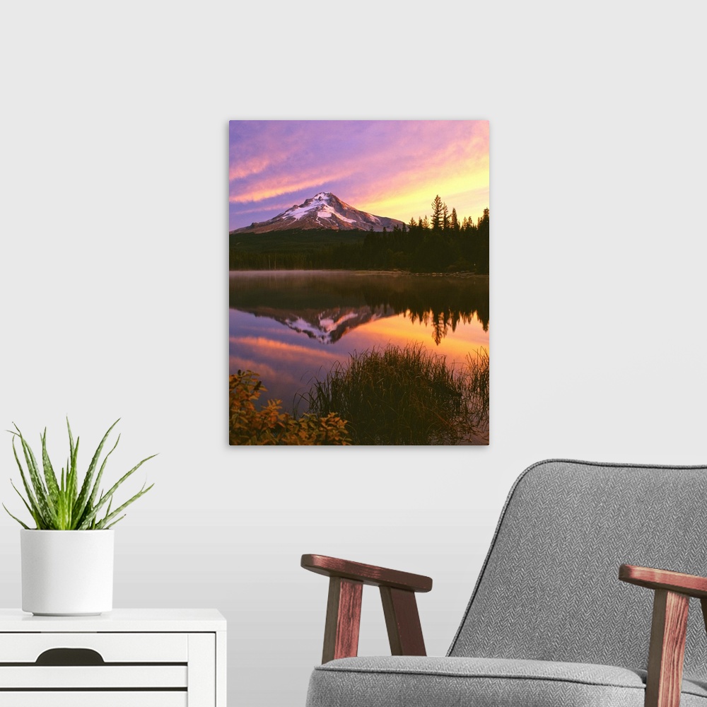 A modern room featuring Mount Hood at sunset reflected in a lake.