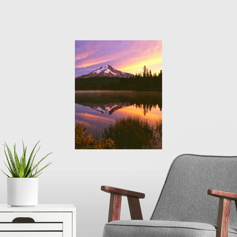 A modern room featuring Mount Hood at sunset reflected in a lake.