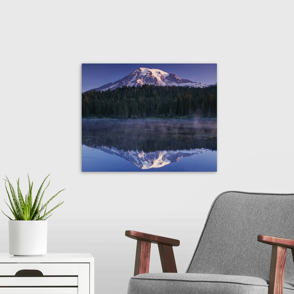 A modern room featuring Mount Rainier and the surrounding forests reflected in a lake, Washington.