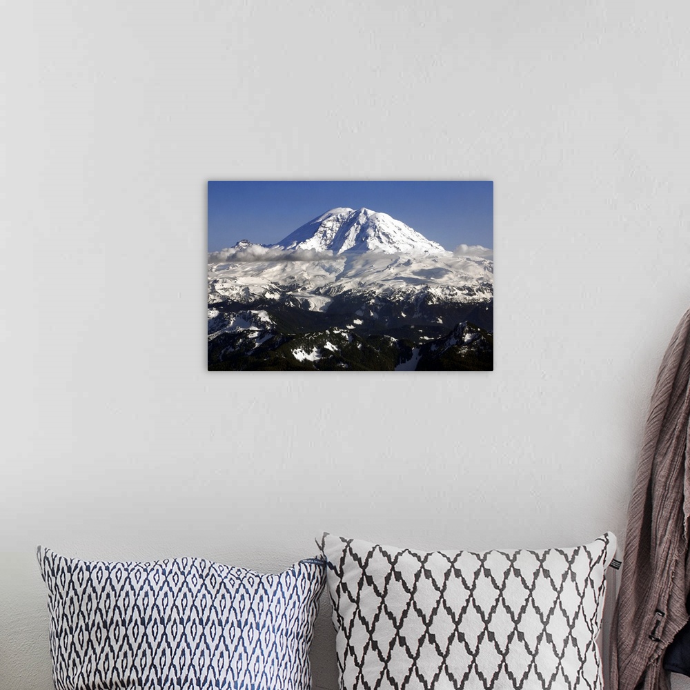A bohemian room featuring Landscape photograph of a snowy Mount Rainier in Washington with low hanging clouds.
