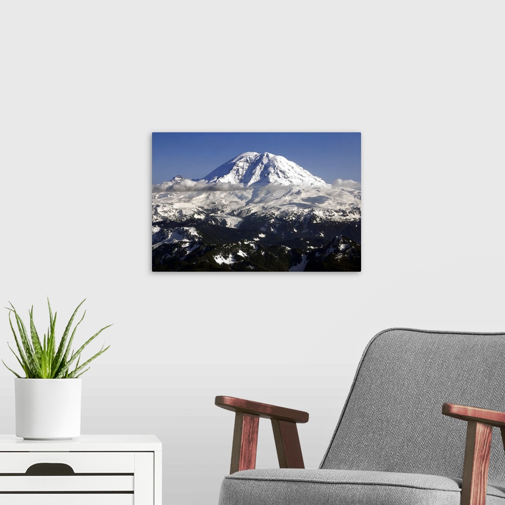 A modern room featuring Landscape photograph of a snowy Mount Rainier in Washington with low hanging clouds.