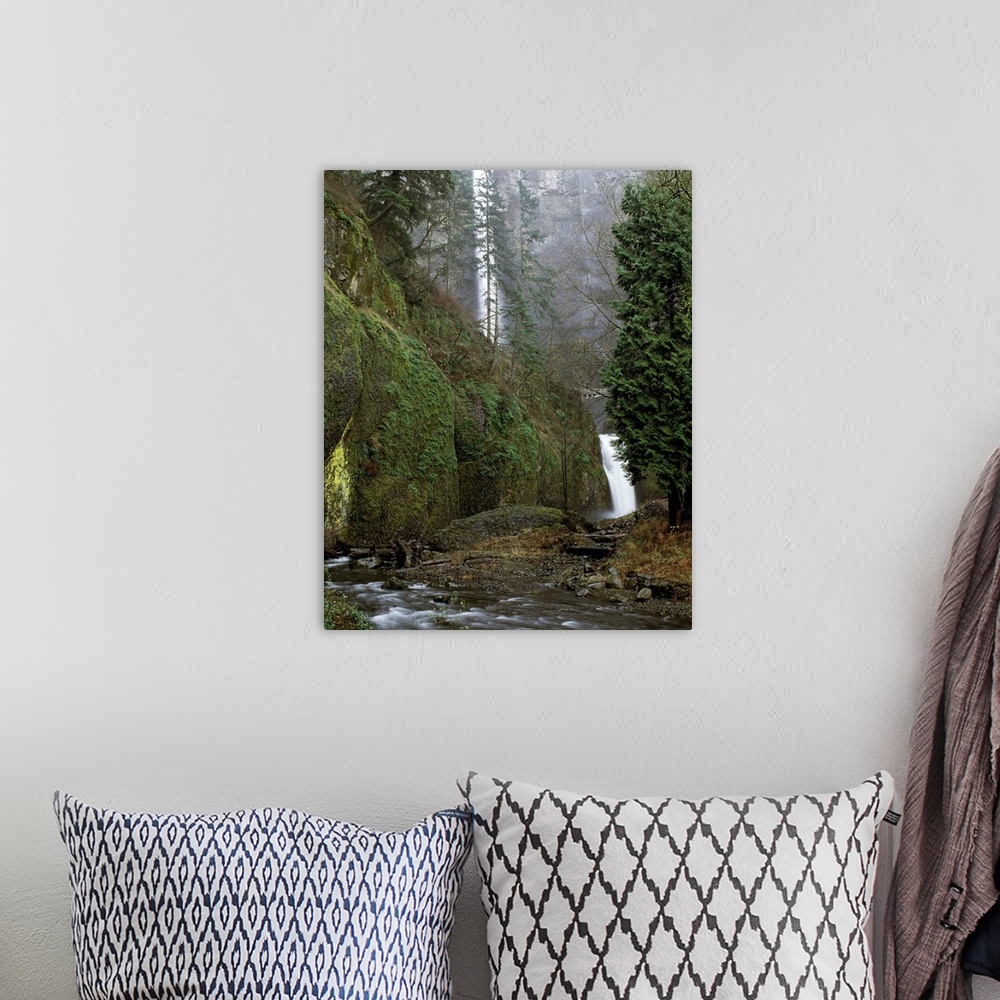A bohemian room featuring Landscape photograph of the Multnomah Falls from a creek side view.
