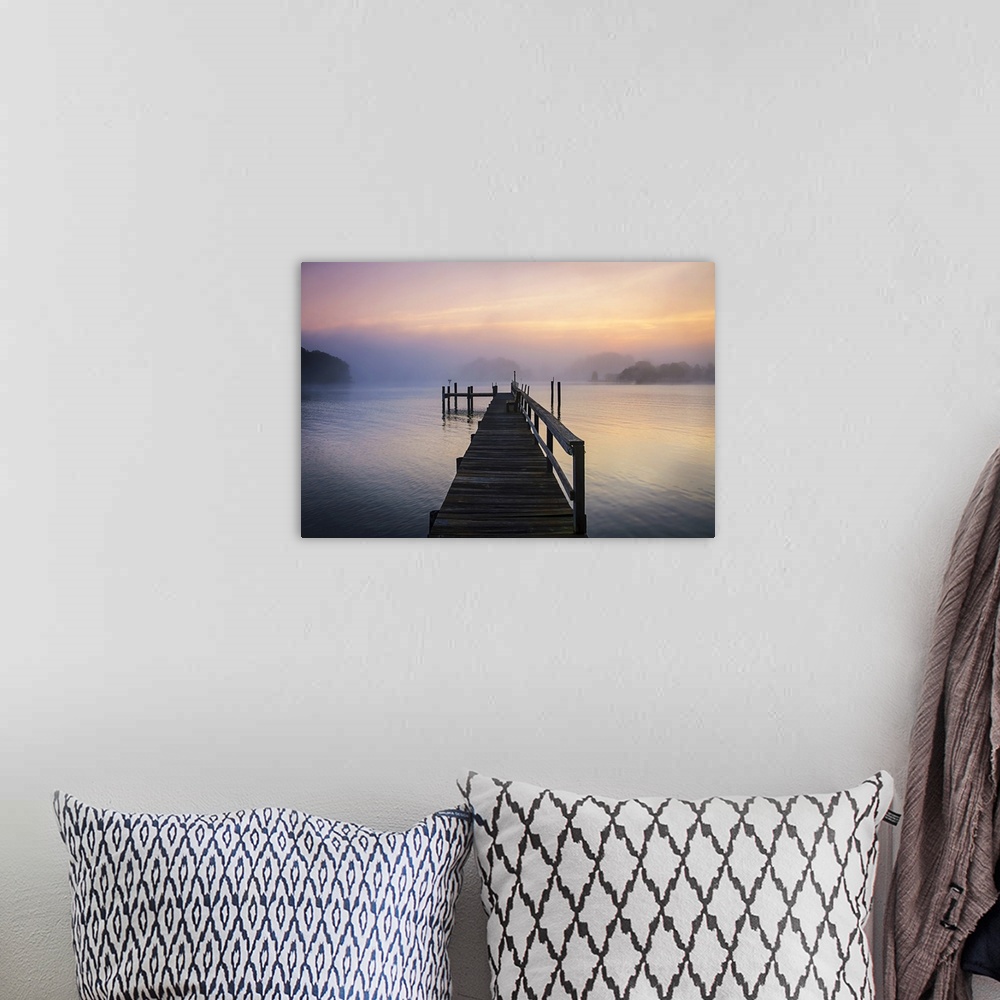 A bohemian room featuring Silhouetted pier on a calm ocean in pastel sunrise light.
