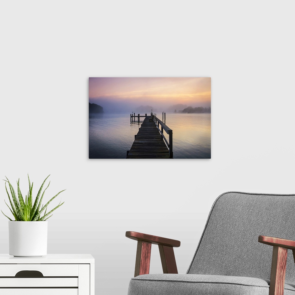 A modern room featuring Silhouetted pier on a calm ocean in pastel sunrise light.