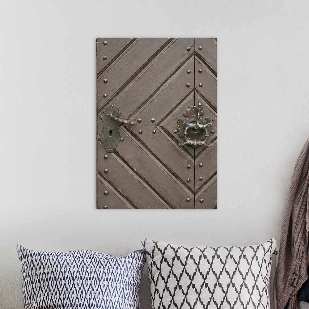 A bohemian room featuring Close up of a wooden door with a diamond pattern and an iron knocker.