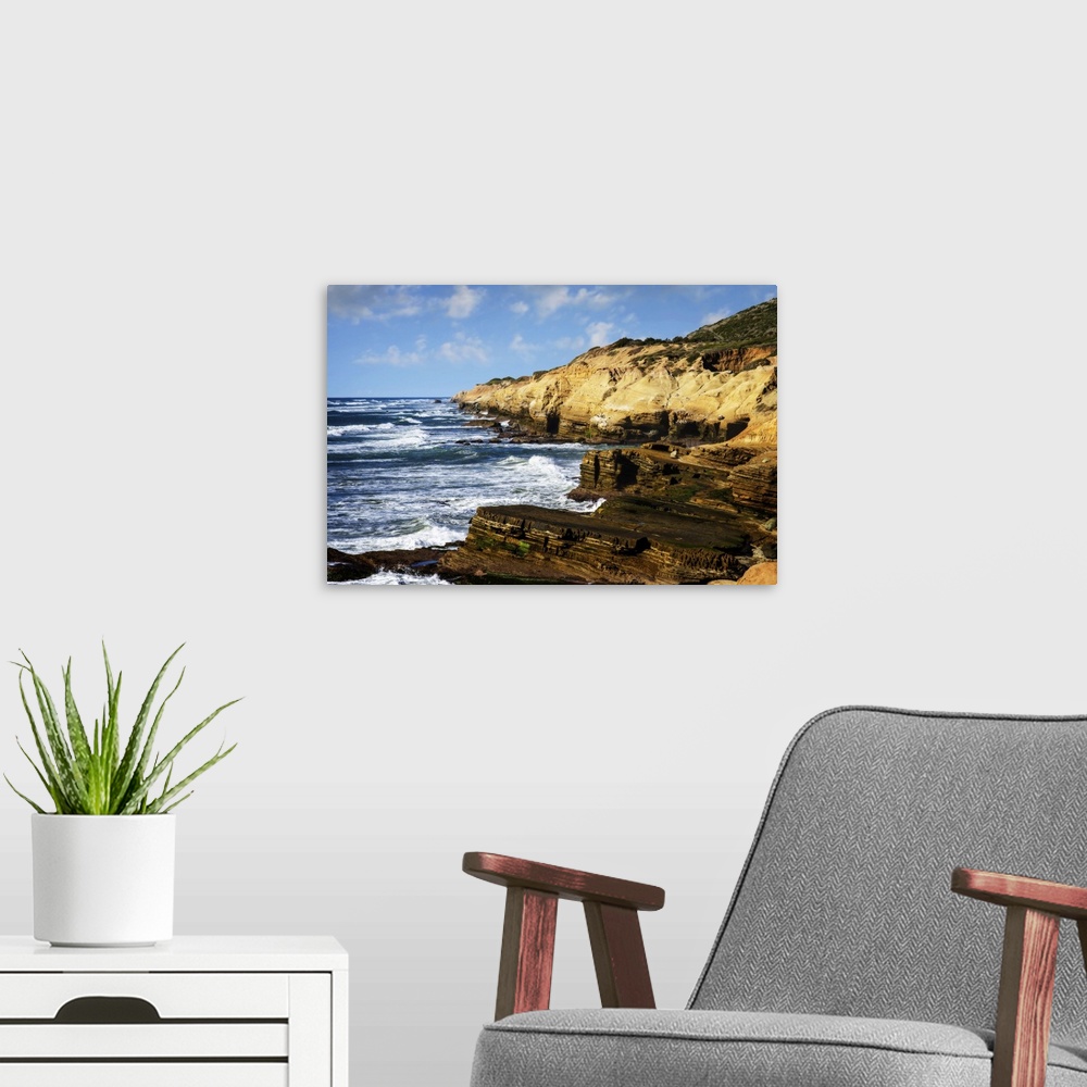 A modern room featuring Landscape photograph of waves crashing on rocky cliffs at Point Loma, CA.