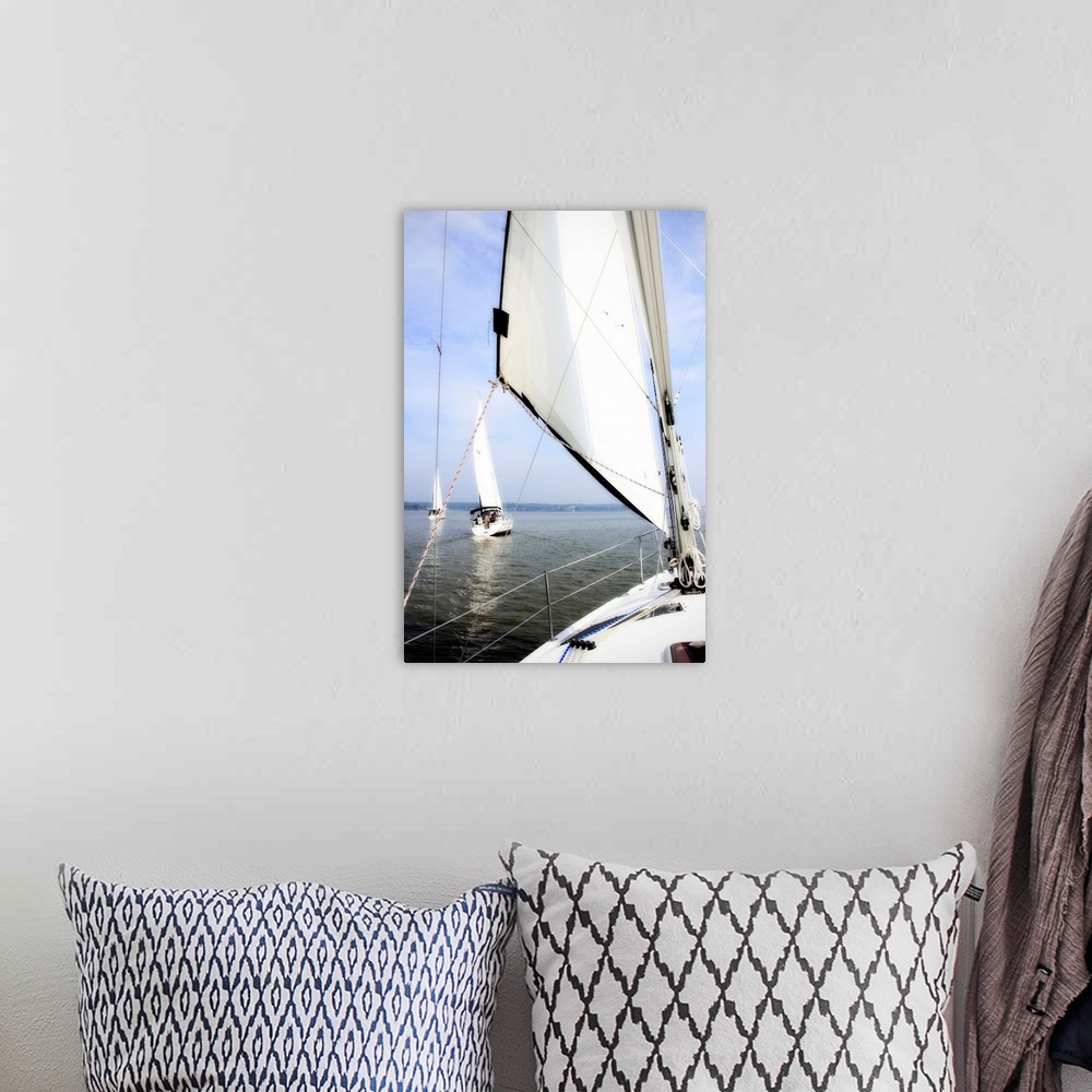 A bohemian room featuring Big vertical photograph of a sail and the front of a sailboat, looking out toward the water where...