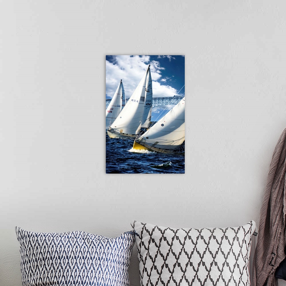 A bohemian room featuring Three sailboats leaning against the wind on dark water.