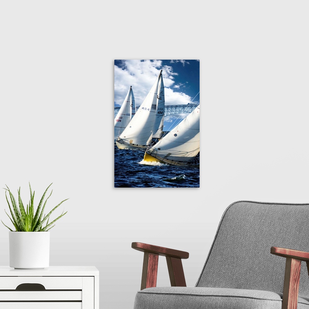 A modern room featuring Three sailboats leaning against the wind on dark water.