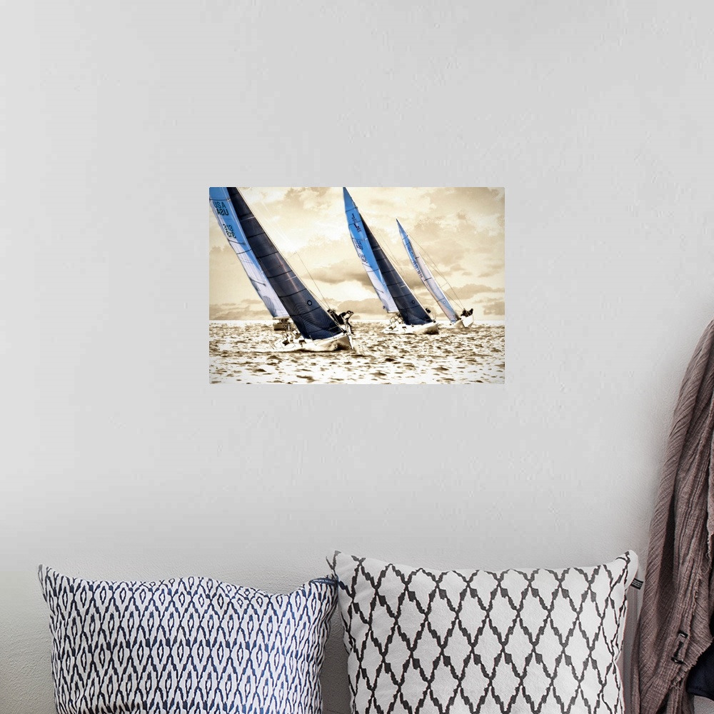 A bohemian room featuring A photograph of three sailboats speeding through the water on a sunny day; this wall art has a br...