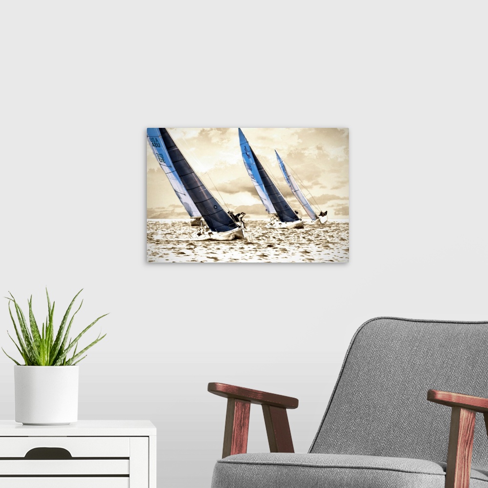 A modern room featuring A photograph of three sailboats speeding through the water on a sunny day; this wall art has a br...