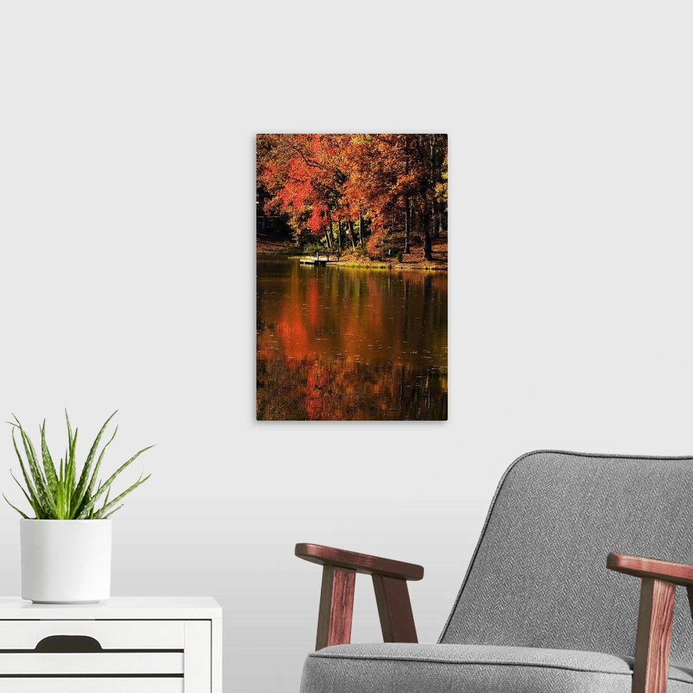 A modern room featuring Vertical photo on canvas of a lake with a dock and fall foliage surrounding it.
