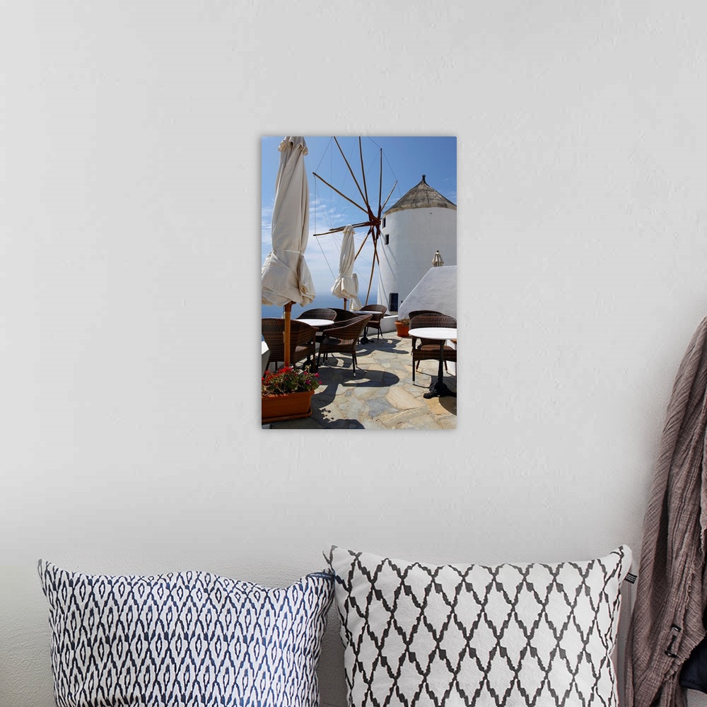 A bohemian room featuring Restaurant on deck with windmill overlooking ocean in Santorini, Greece