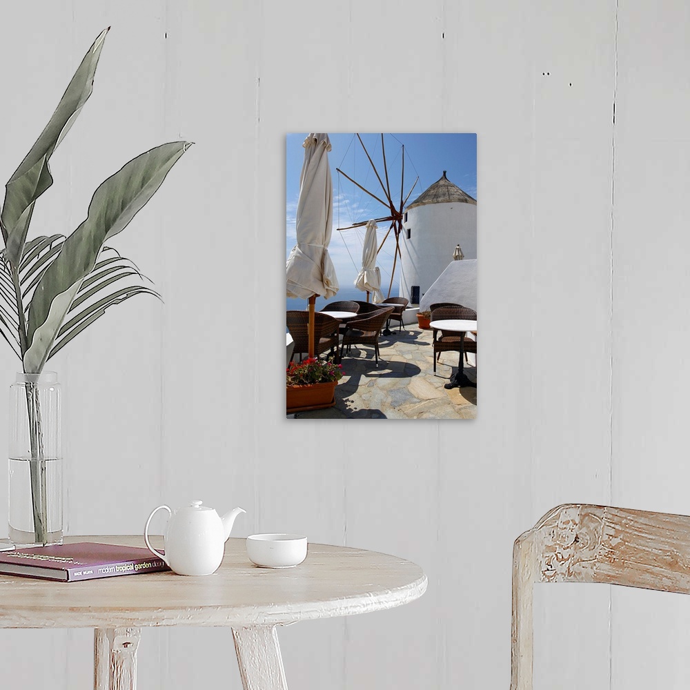 A farmhouse room featuring Restaurant on deck with windmill overlooking ocean in Santorini, Greece