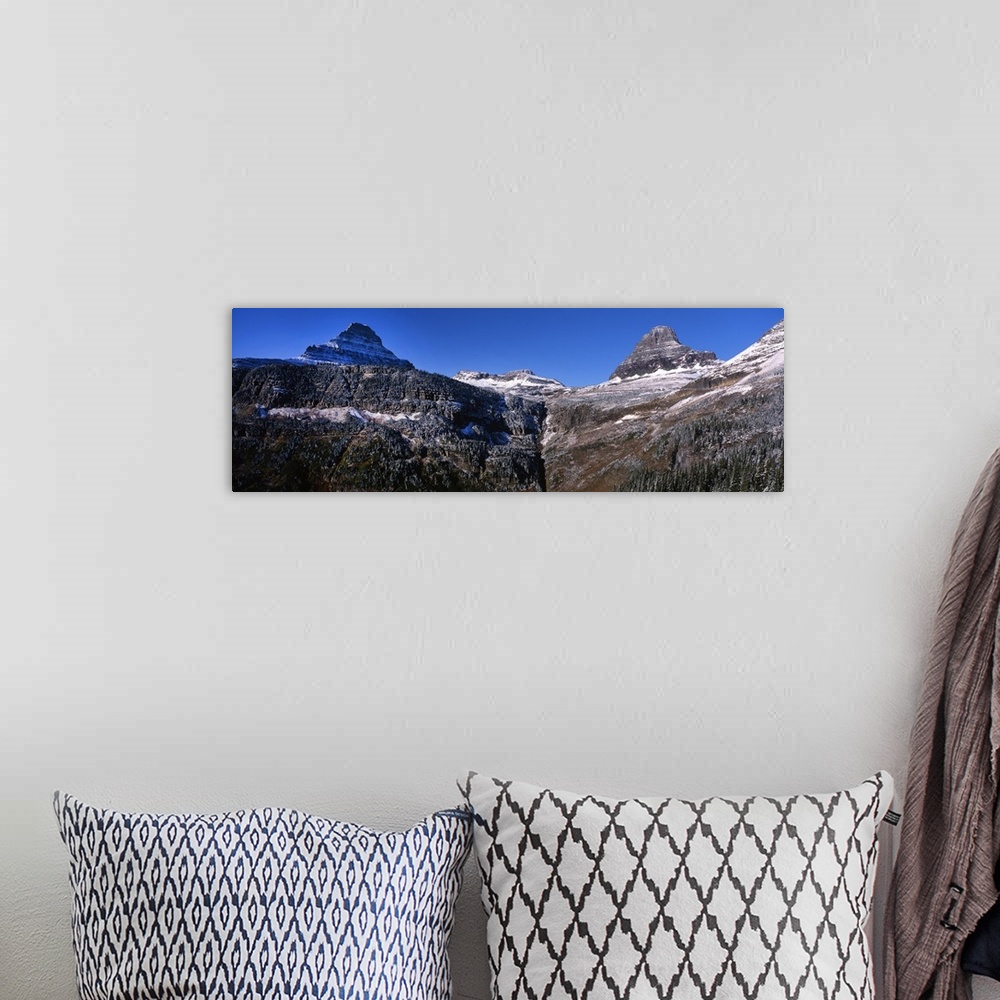 A bohemian room featuring Panoramic photograph of snow covered mountains at Glacier National Park.