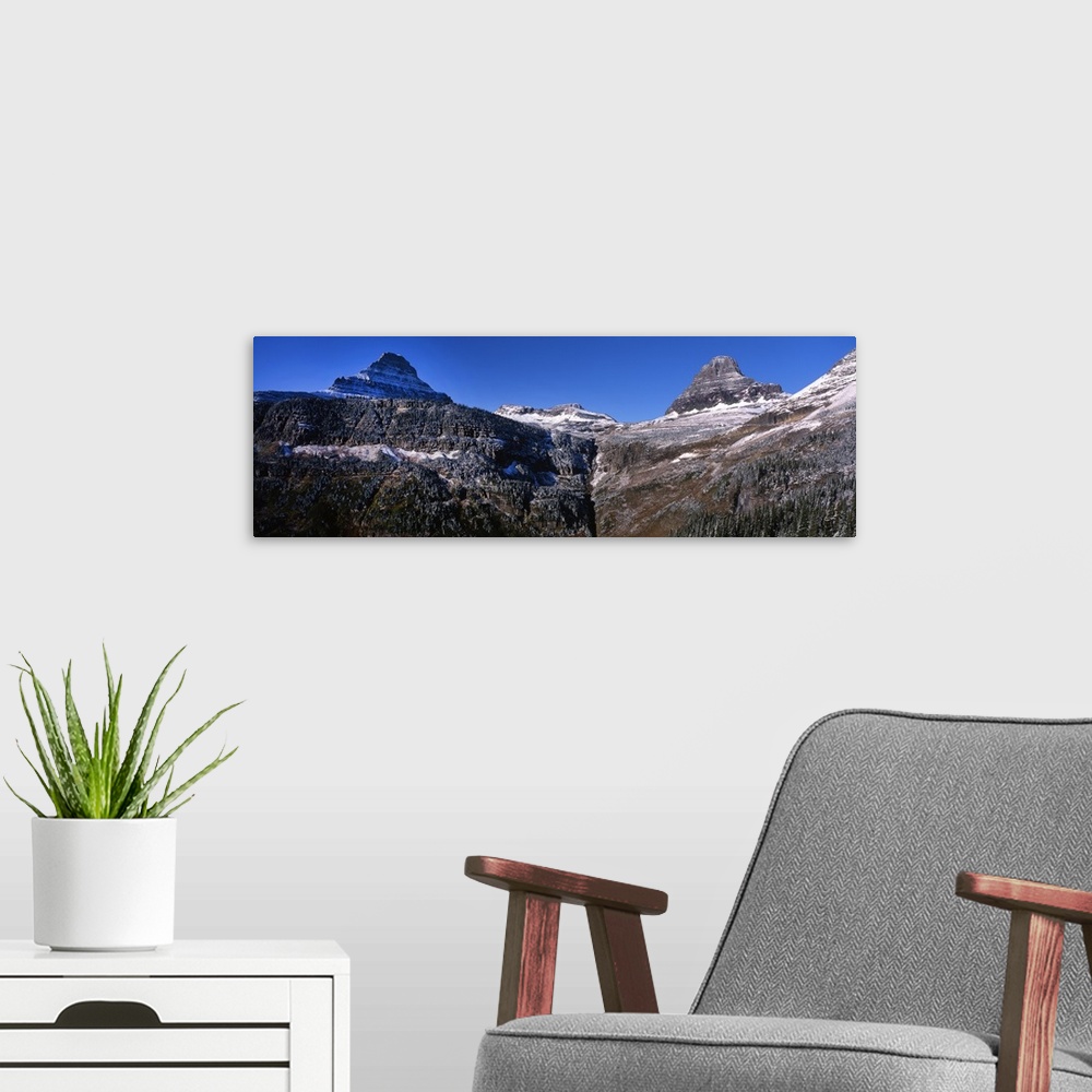 A modern room featuring Panoramic photograph of snow covered mountains at Glacier National Park.