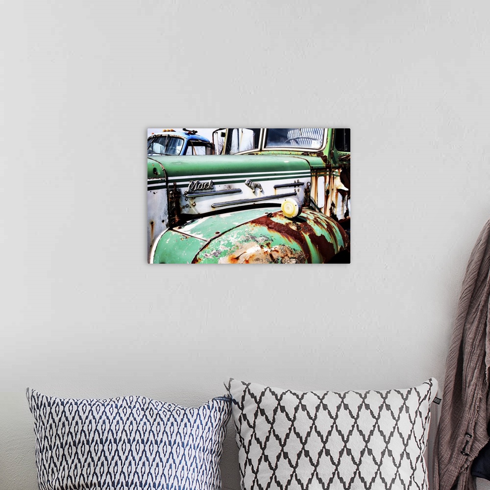 A bohemian room featuring Photograph of the side of an old, rusted, green and white Mack truck.