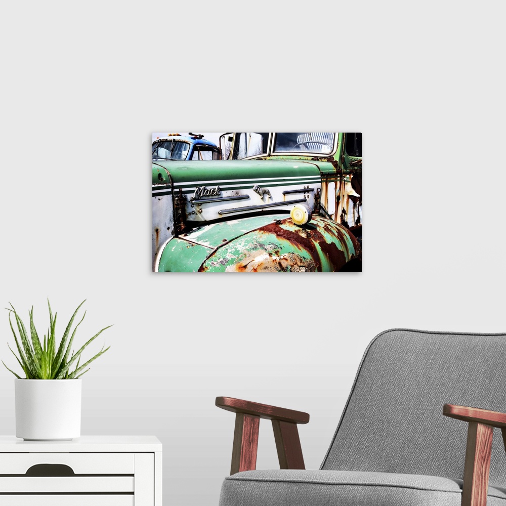 A modern room featuring Photograph of the side of an old, rusted, green and white Mack truck.