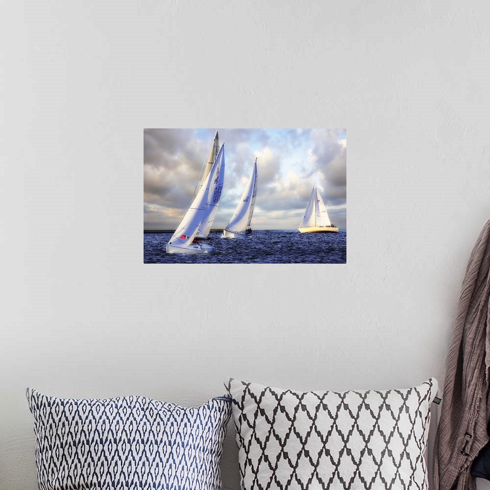 A bohemian room featuring Several sail boats are pictured in open water and the sky filled with grey clouds.