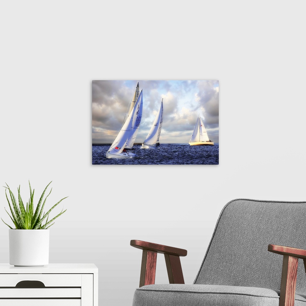 A modern room featuring Several sail boats are pictured in open water and the sky filled with grey clouds.