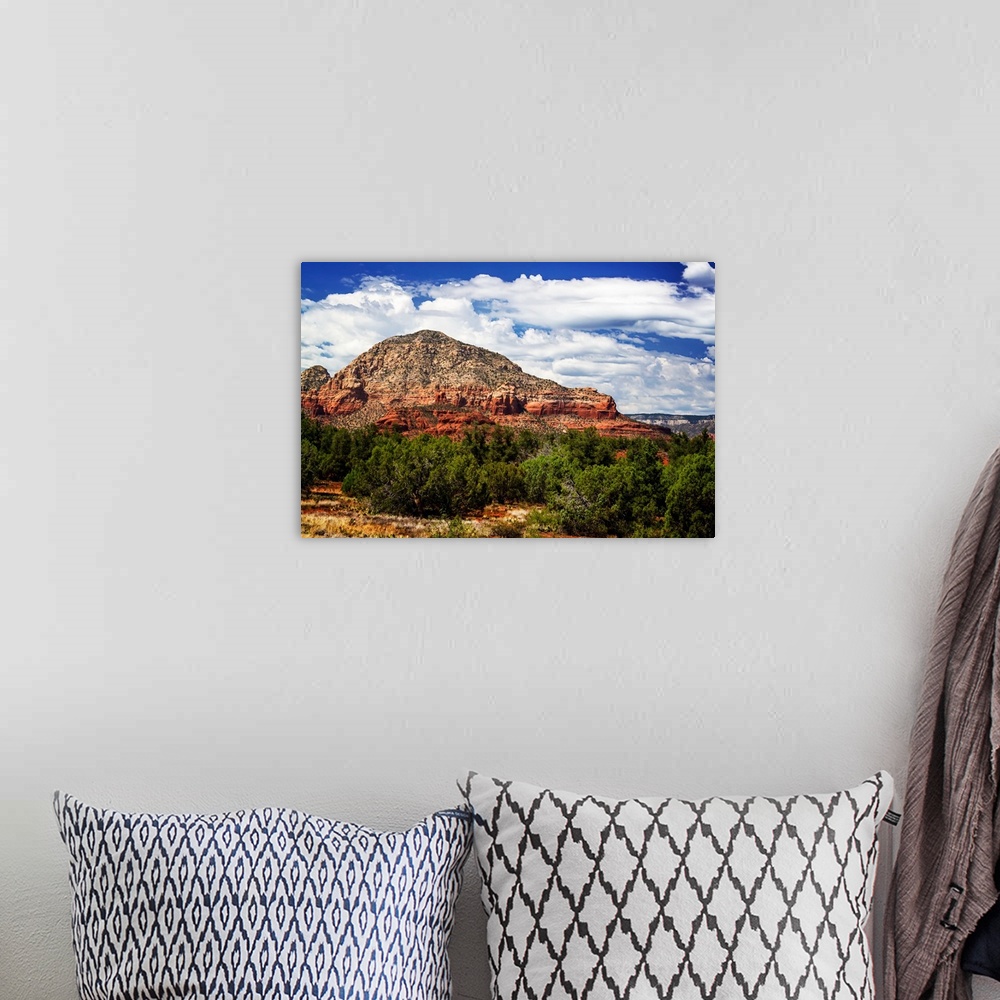 A bohemian room featuring Landscape photograph of a rock formation in Sedona under blue, cloudy skies.