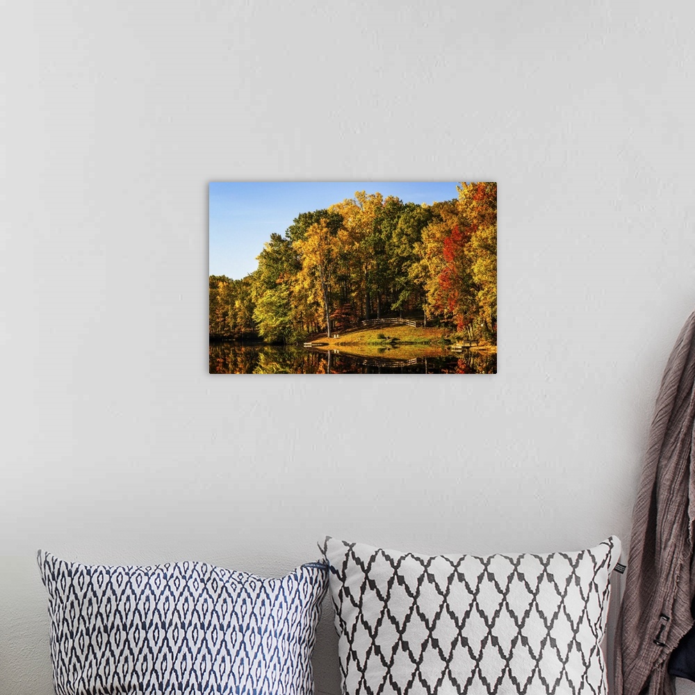 A bohemian room featuring Landscape photograph of a lake reflecting Autumn trees.