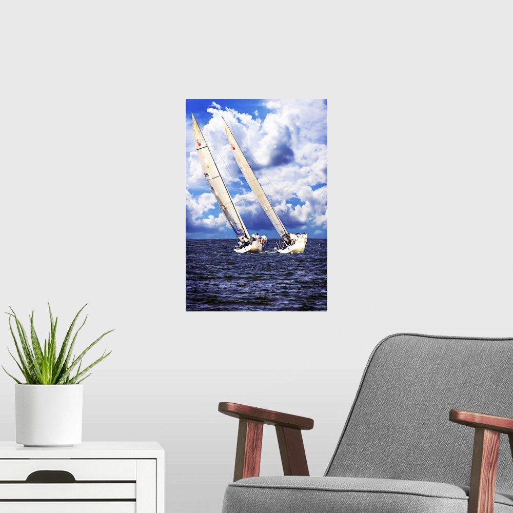 A modern room featuring Two sailboats on the water leaning against the wind with large clouds in the sky.