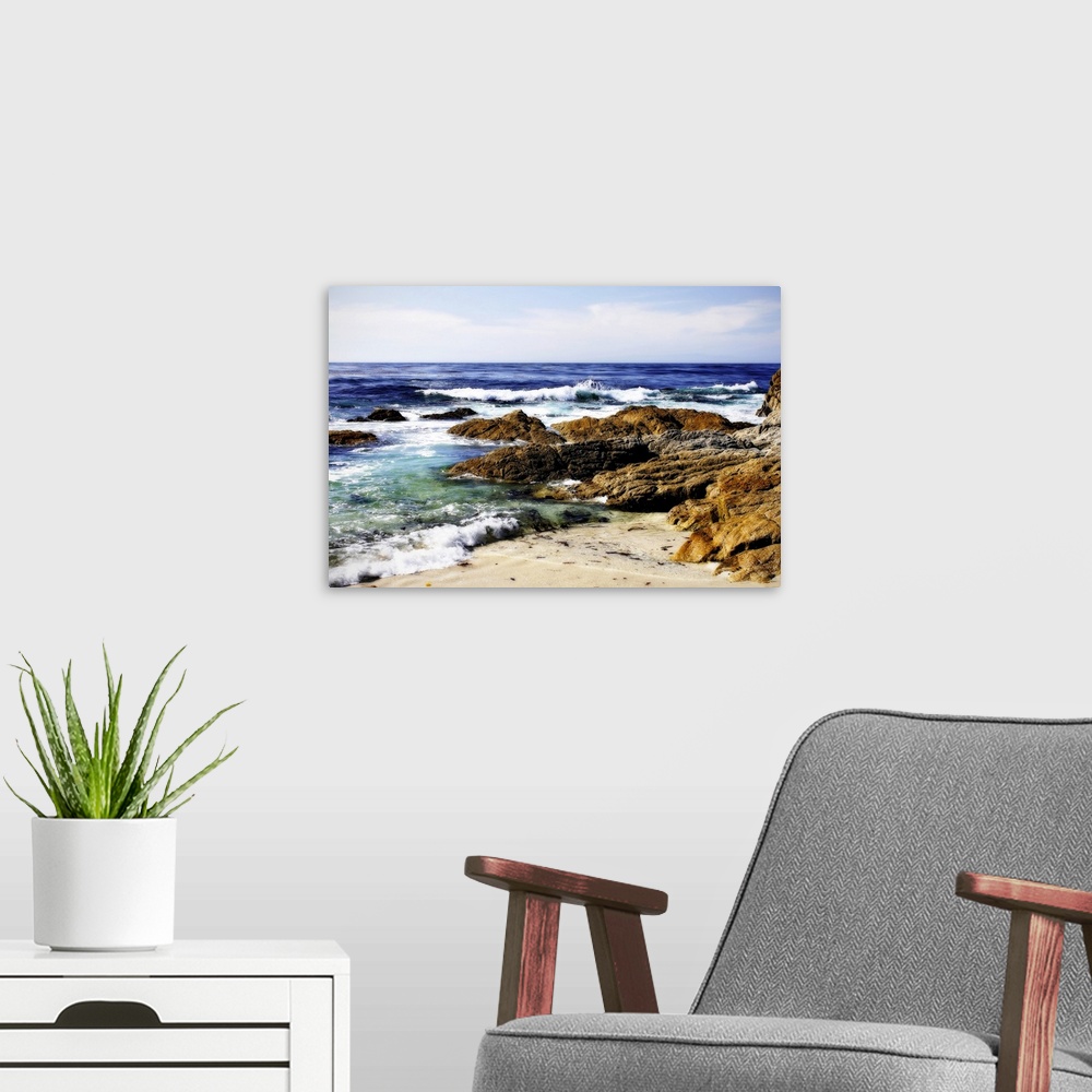 A modern room featuring Photograph of rocky shoreline with waves crashing in.