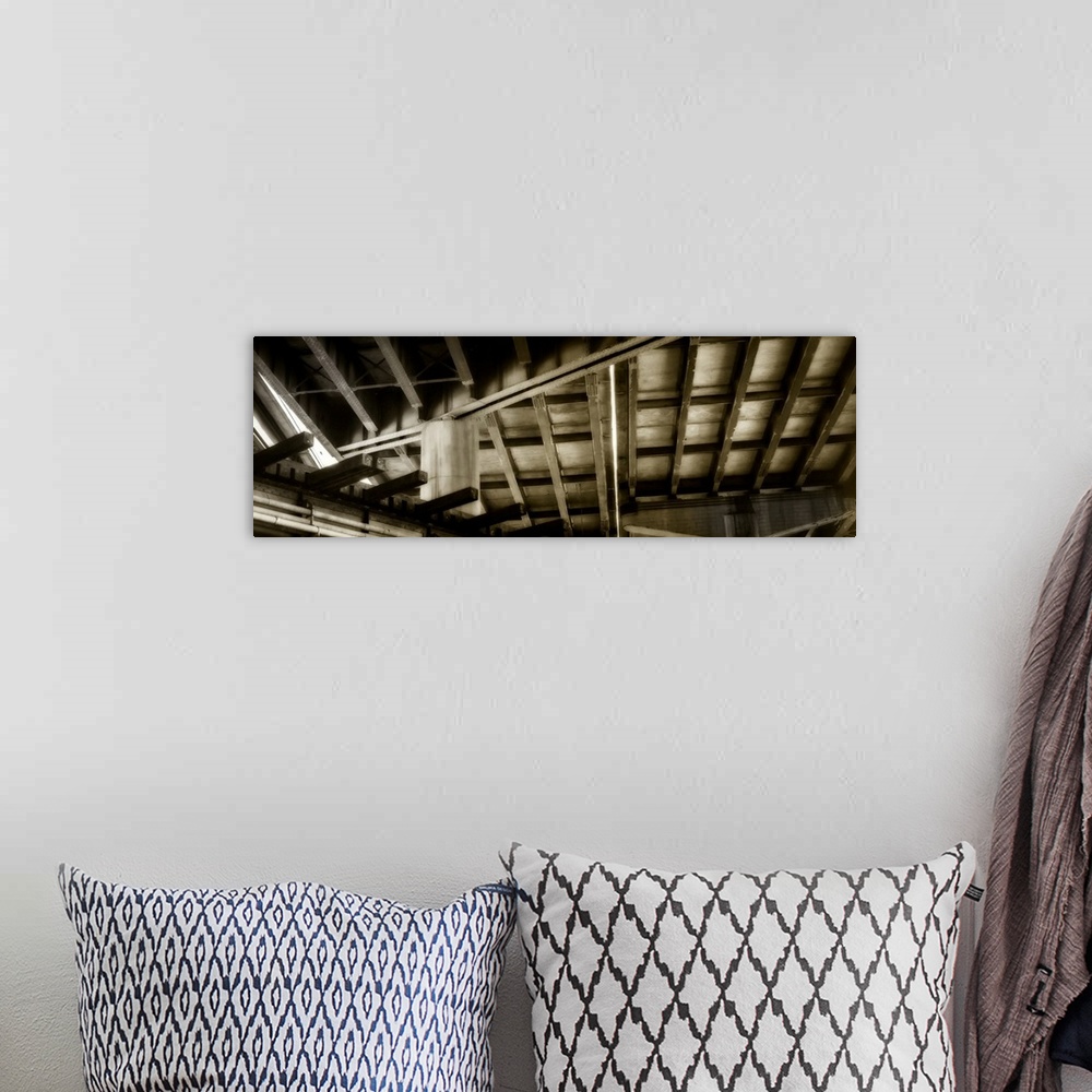A bohemian room featuring Abstract sepia toned panoramic photograph of ceiling rafters creating intriguing angles.