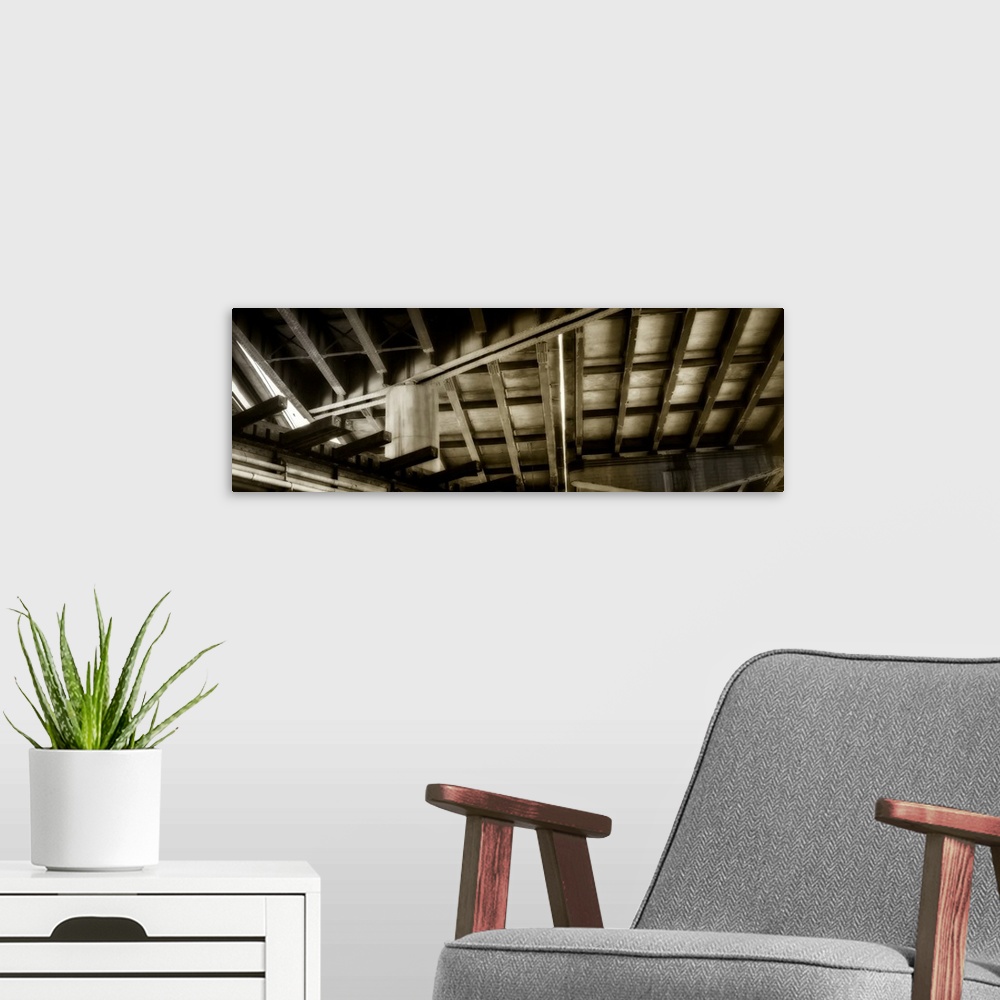 A modern room featuring Abstract sepia toned panoramic photograph of ceiling rafters creating intriguing angles.