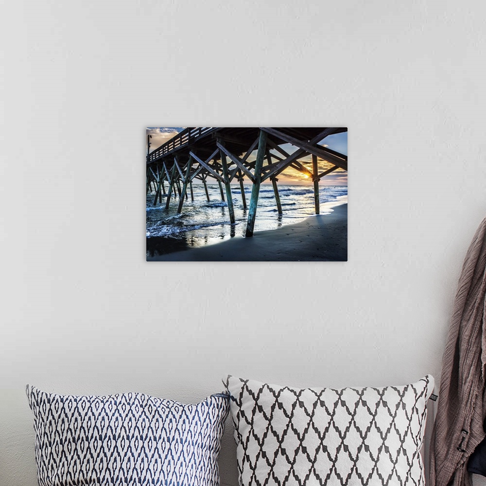 A bohemian room featuring View of a sunrise over the ocean from underneath a wooden pier.