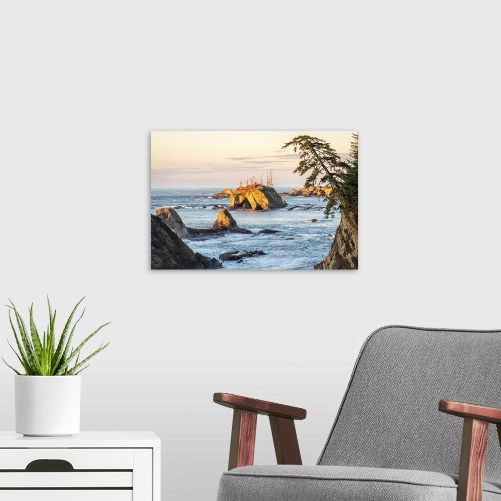 A modern room featuring Landscape photograph of the sunset over rock formations in Sunset Bay State Park, Oregon.