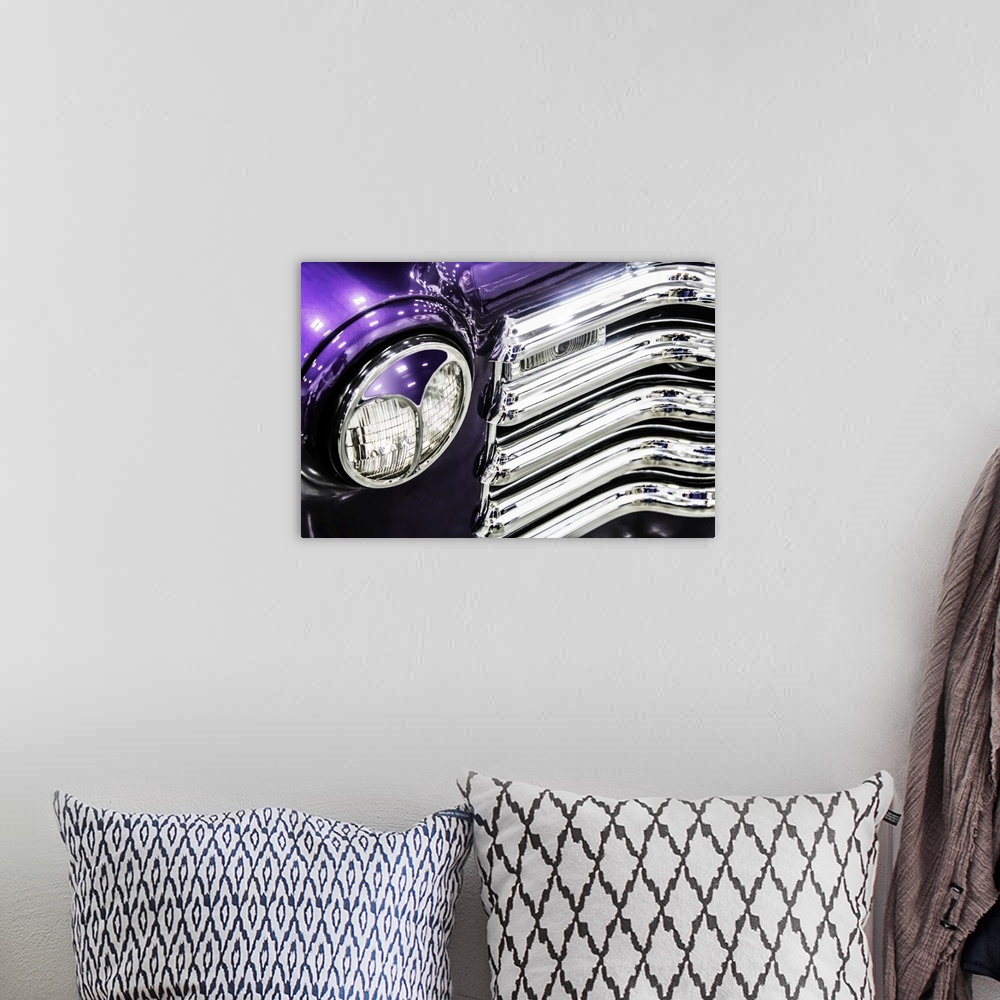 A bohemian room featuring Headlight and grill detail of a bright purple vintage truck.
