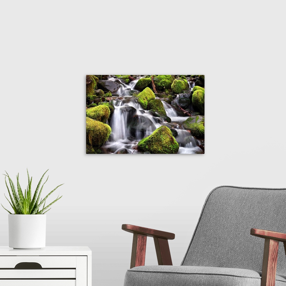 A modern room featuring Long exposure photograph of a rocky waterfall lined with bright green moss covered rocks.