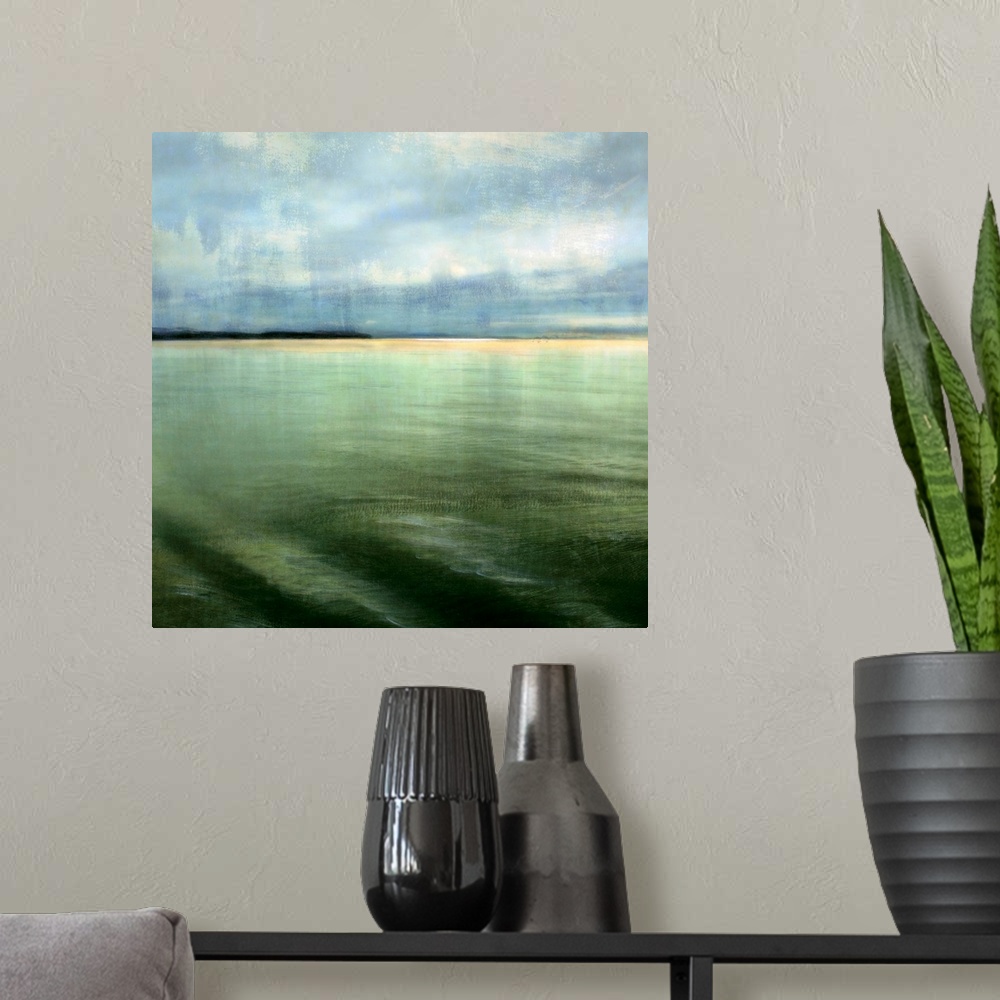 A modern room featuring Big square canvas art shows calm waters in the foreground slowly hitting the beach in the backgro...