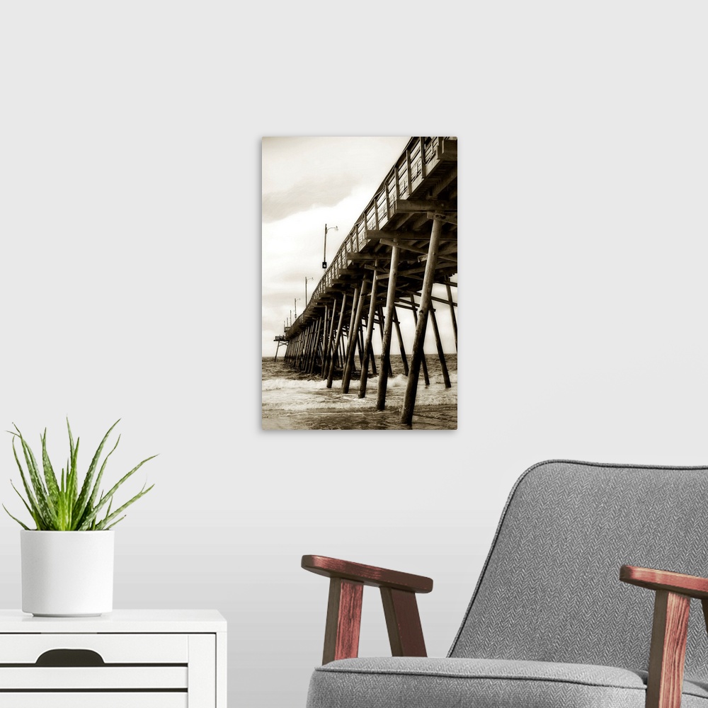 A modern room featuring Photograph of dock stretching into ocean under cloudy sky.