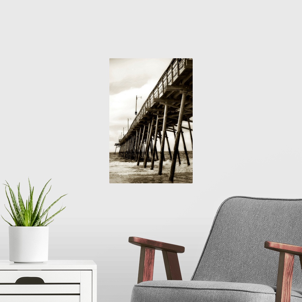 A modern room featuring Photograph of dock stretching into ocean under cloudy sky.