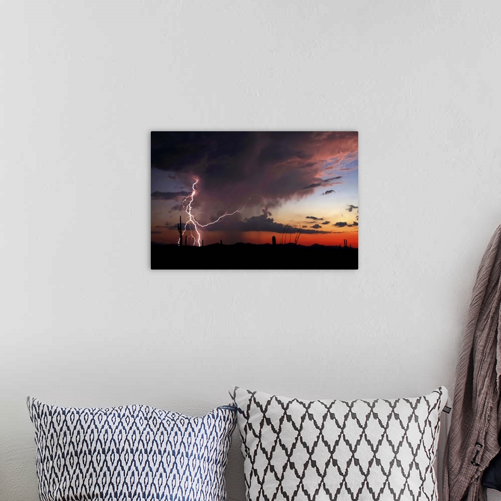 A bohemian room featuring Silhouetted landscape photograph of a desert sunset with dramatic clouds and lightning bolts.