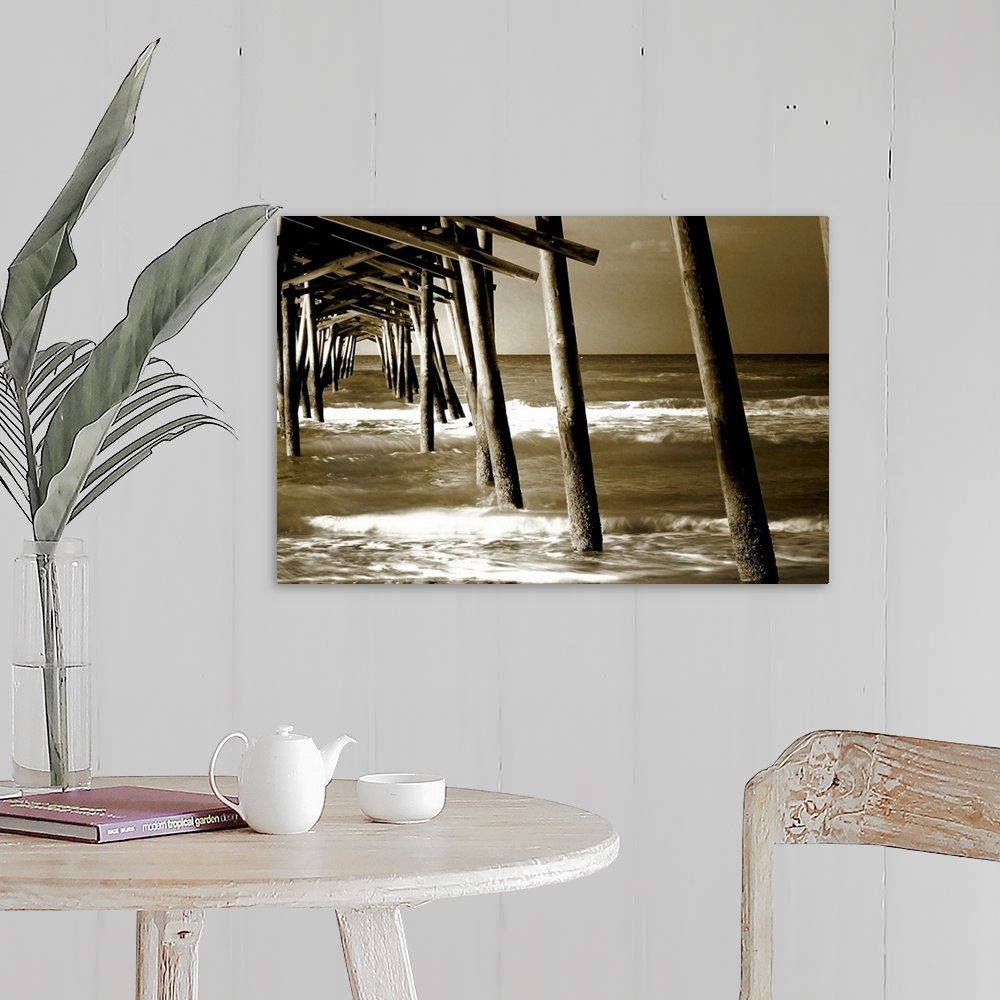 A farmhouse room featuring Photograph underneath a wooden pier with waves rolling in.