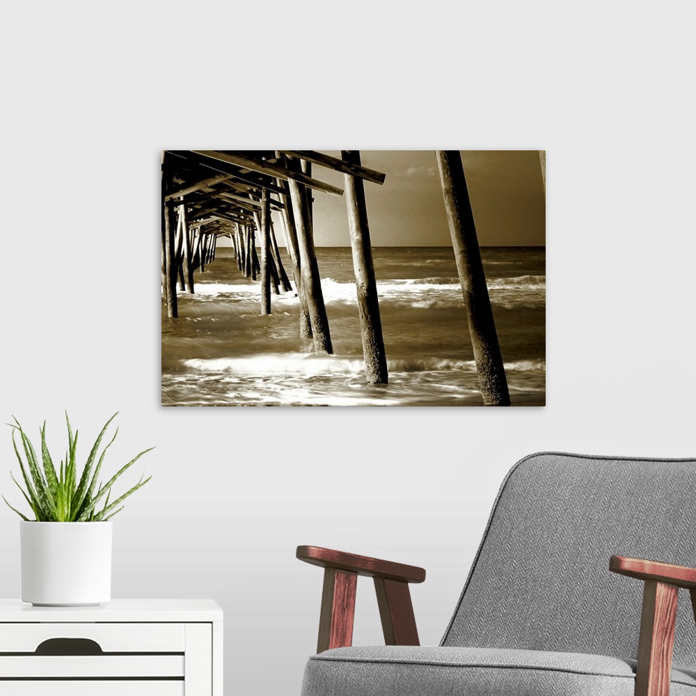A modern room featuring Photograph underneath a wooden pier with waves rolling in.