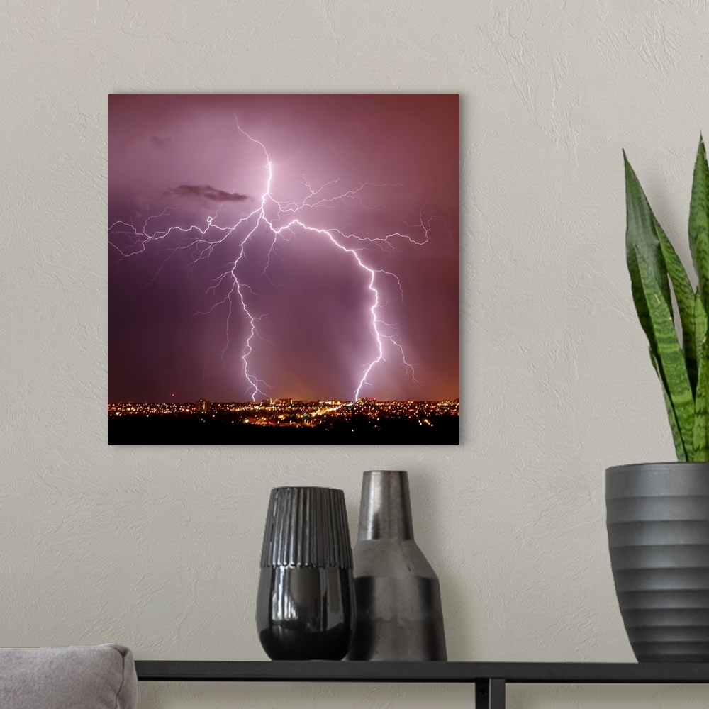 A modern room featuring Square photograph of lightning striking above a city in Arizona.
