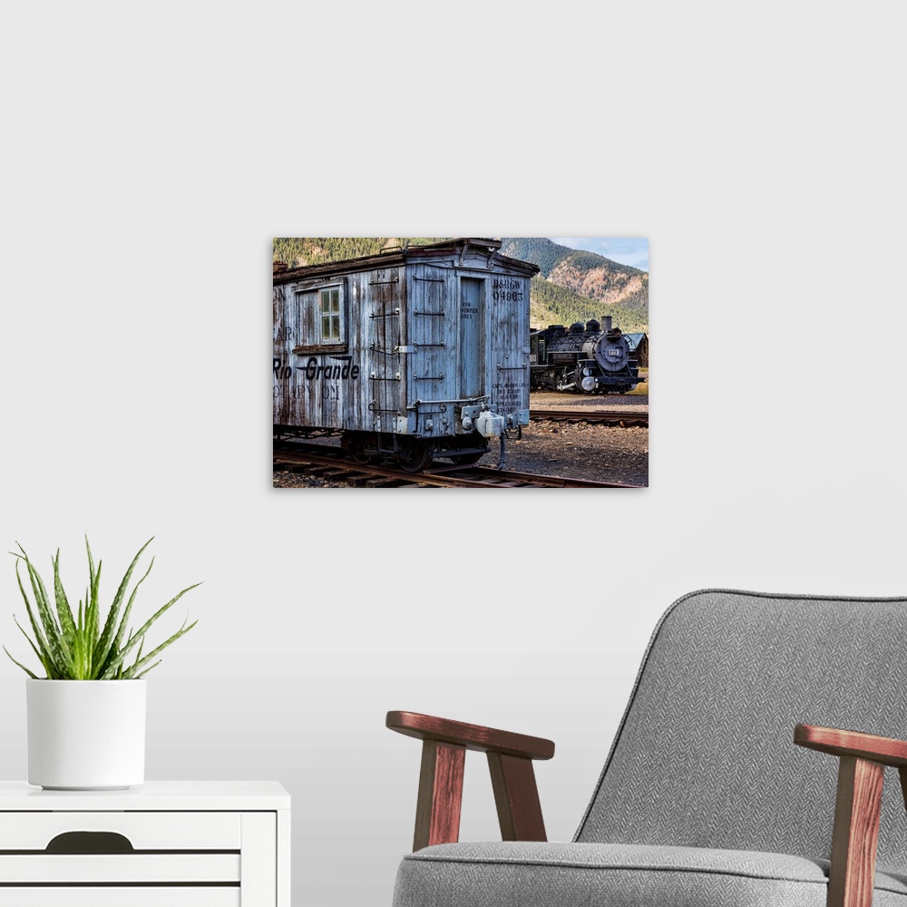 A modern room featuring Photograph of a vintage train car on the railroad tracks.